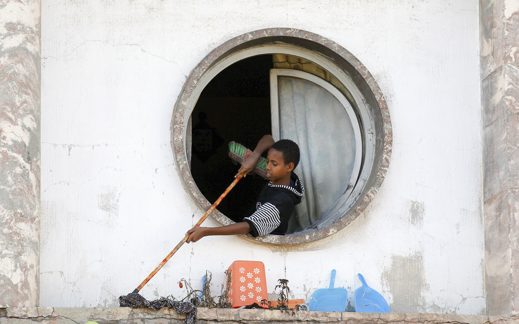 A boy cleans the outside of the Bar Zilli building on Beirut Street in Eritrea's capital Asmara, February 20, 2016. REUTERS/Thomas Mukoya