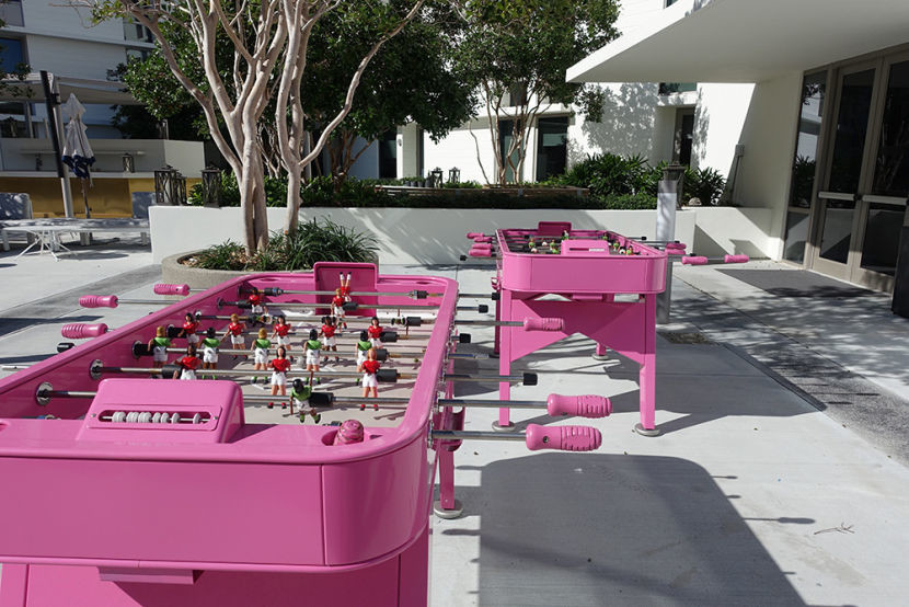 A pair of lonely bright pink foosball tables.