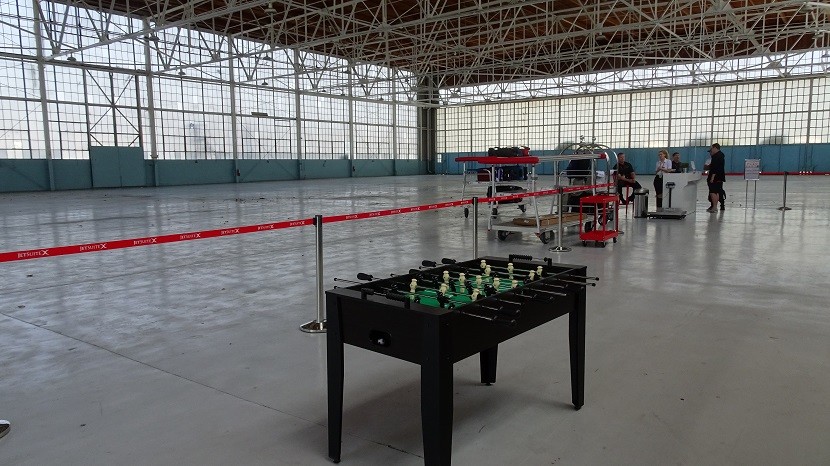 The roomy hangar functions as check-in counter, baggage claim, and Foosball stadium.