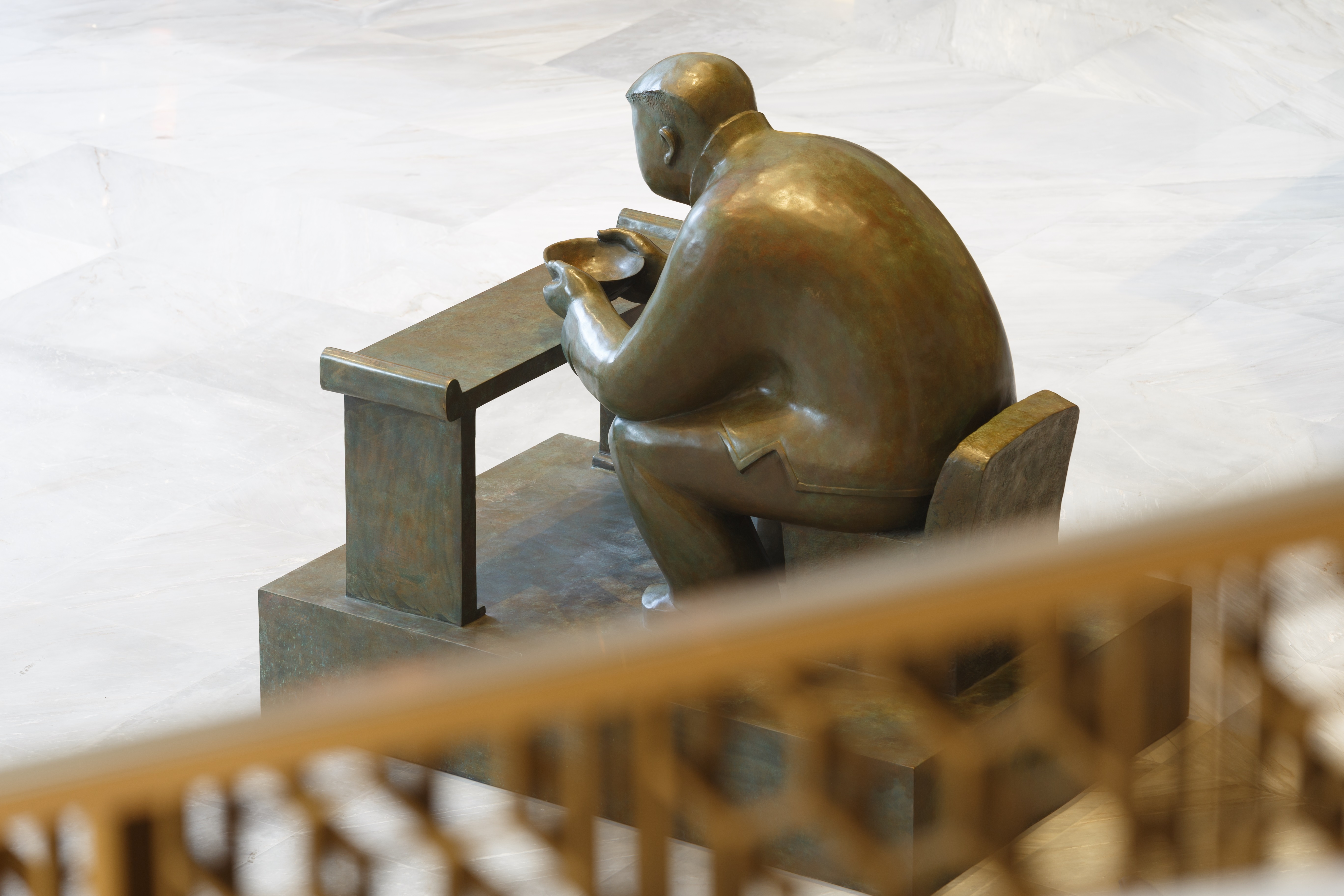 Bronze sculpture of a man drinking tea in the lobby