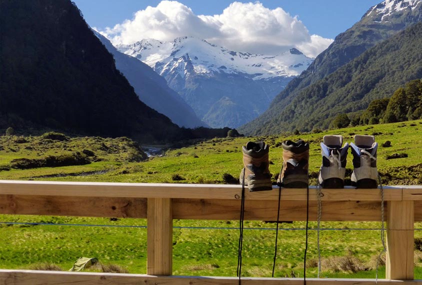 Two pairs of boots dry on a fence at the head of a valley.