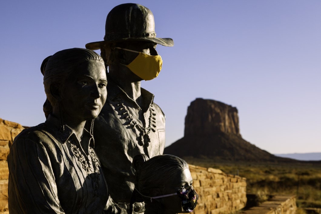 WINDOW ROCK, UTAH/USA - JULY 1 2020 : Two of three statues of the Native American family outside of Monument Valley wear face masks for COVID-19, the mother is unmasked, the park is closed.